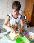 Внук выкладывает кукурузные палочки в виде домика