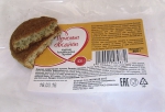Печенье овсяное "Русский хлеб" в разломе на фоне упаковочного пакета с информацией о производителе и составе