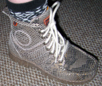 Нога в ботинке, вид со внешней стороны, ярко выделяются пришитый логотип