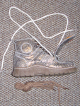 Вид на расшнурованный ботинок сбоку. Альтернативный шнурок бежевого цвета