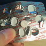 Таблетка препарата Полиоксидоний с отпечатанными буквами ПО