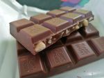 Орешки кешью равномерно распределены по плитке шоколада