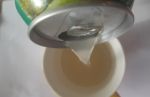 Струя напитка You Vietnam со вкусом "Анонна", переливаемого из банки в чашку.