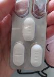 Белые таблетки Вильпрафен Солютаб  продолговатой формы с надписями дозировки и риской