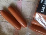 Извлекает сосиски из упаковки